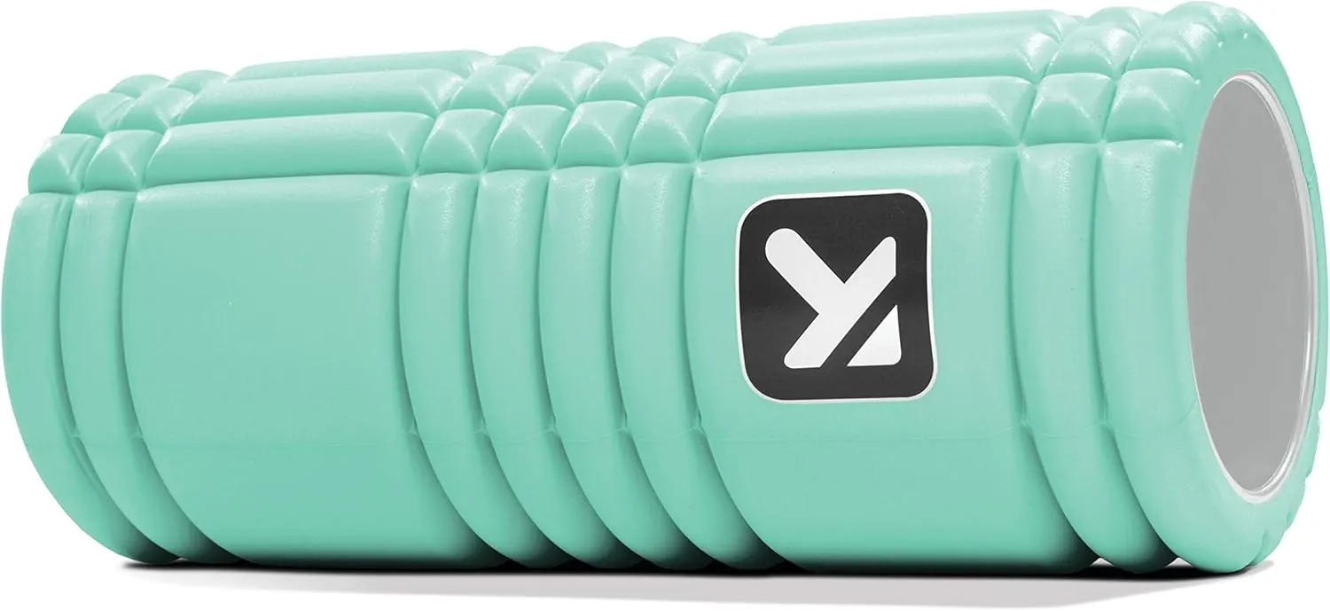 TriggerPoint GRID foam roller lying on its side showing the three-zone surface pattern of flat, channel, and raised grid sections